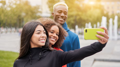 Portrait of smiling young woman using mobile phone