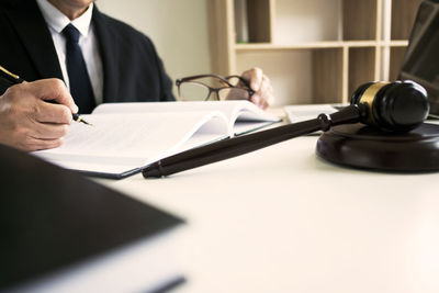Midsection of man holding camera on table