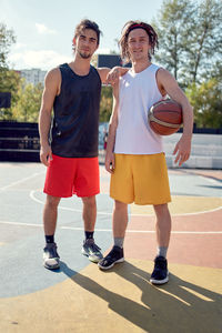 Portrait of young athletes standing at basketball court