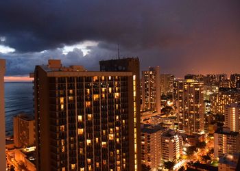 Illuminated cityscape against sky at night