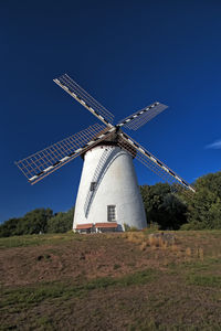 Traditional windmill on field against sky