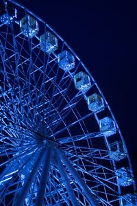 Low angle view of illuminated ferris wheel against sky at night