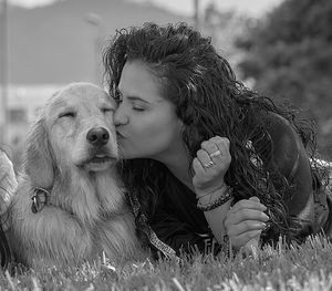 Portrait of woman with dog on field