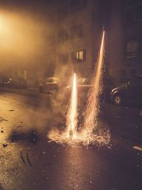 Close-up of wet illuminated light against sky during sunset
