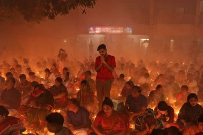 Praying at rakher upobash infront of burning candle and incense at rakher upobash baradi