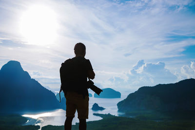 Silhouette man standing on mountain against sky