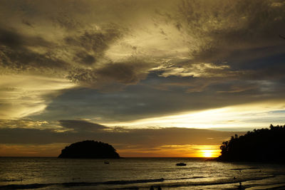 Scenic view of sea against dramatic sky during sunset