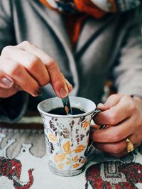 Midsection of woman holding coffee cup