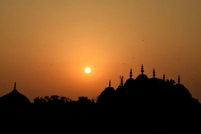 Silhouette of temple building against sky during sunset