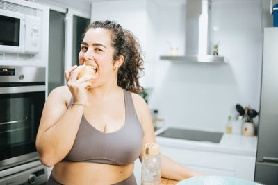 Young woman drinking water in bathroom