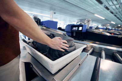 Airport security check. young man waiting for x-ray control his bag.