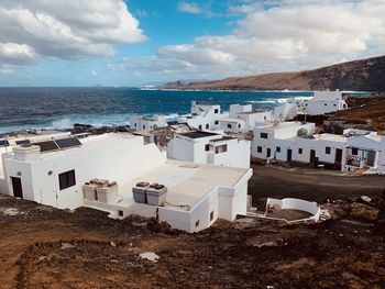 High angle view of buildings by sea against sky