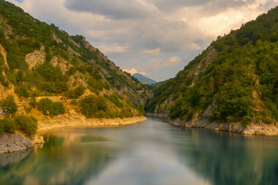 Scenic view of river amidst mountains against sky