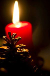 Close-up of lit candle in dark room