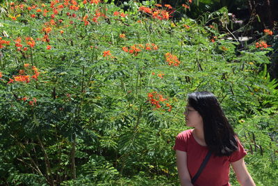 Full length of woman standing against plants