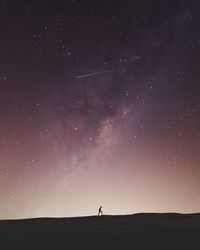 Silhouette of person against star field at night