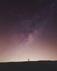 Silhouette of person standing against star field