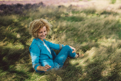 Portrait of a smiling woman sitting on field