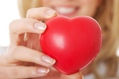 Young woman holding hart shapes against white background