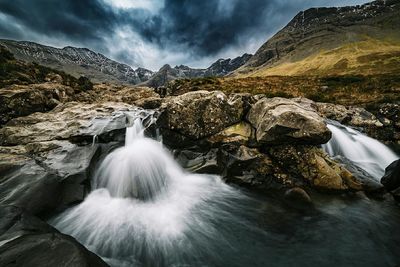 Scenic view of mountains against cloudy sky