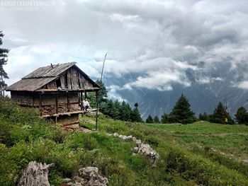 House amidst trees and buildings against sky