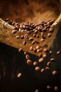 Roasted coffee beans being poured out of woven bamboo basket