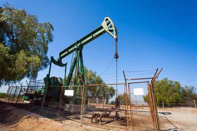 Built structure on field against clear blue sky