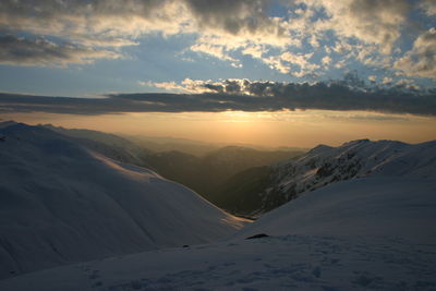 Scenic view of snowcapped mountains against sky during sunset