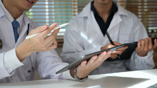 Midsection of doctor examining patient in clinic