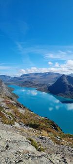 Scenic view of lake and mountains against blue sky