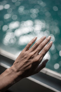 Cropped hand touching window