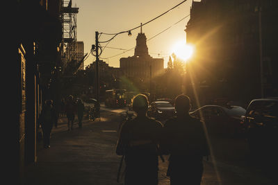 Rear view of silhouette people walking on city street