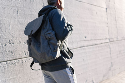 Rear view of man standing against wall