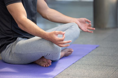 Low section of man sitting on table