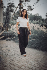 Young woman standing on footpath