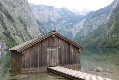 Built structure by lake against mountains