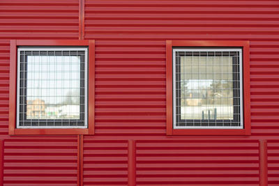 Window in red wall. window with grille. details of building. protected wall.