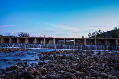 View of bridge over river against blue sky