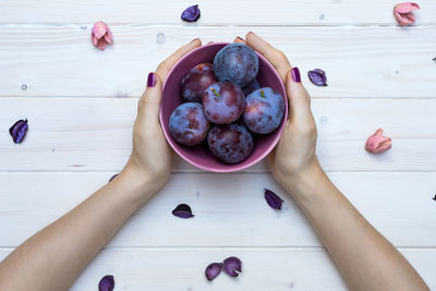 High angle view of hand holding fruits on table