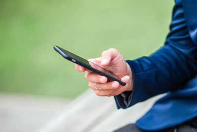 Midsection of man using mobile phone