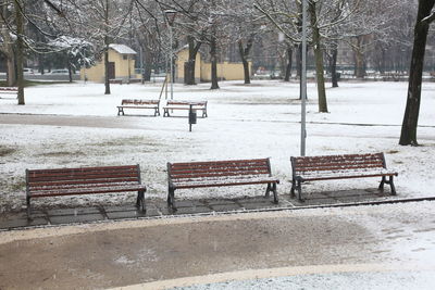 Empty bench in park during winter