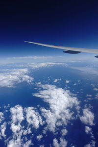 Cropped image of airplane flying over clouds