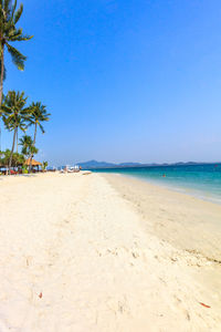 Scenic view of beach against clear blue sky