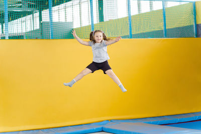 Full length portrait of happy girl jumping