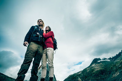 Low angle view of smiling young woman against sky