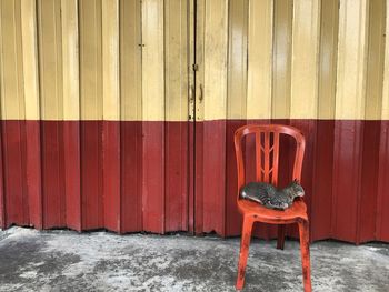 Empty chair against red wall