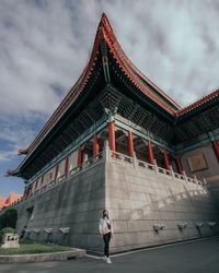 Full length of woman standing against cloudy sky