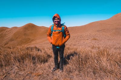 Full length of smiling standing on land against sky