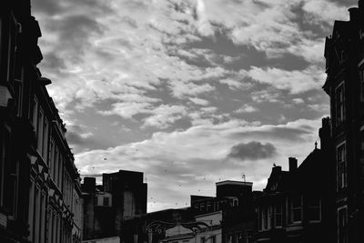 Low angle view of buildings against cloudy sky