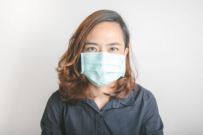 Portrait of mid adult woman against white background